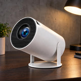 Smart mini projector with Bluetooth 5.0 and HD display sitting on a dark oak desk surface.